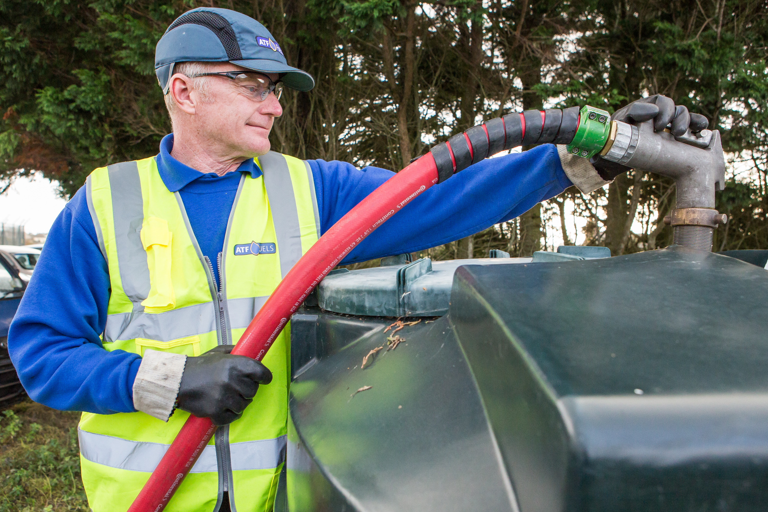image of a man filling an oil tank