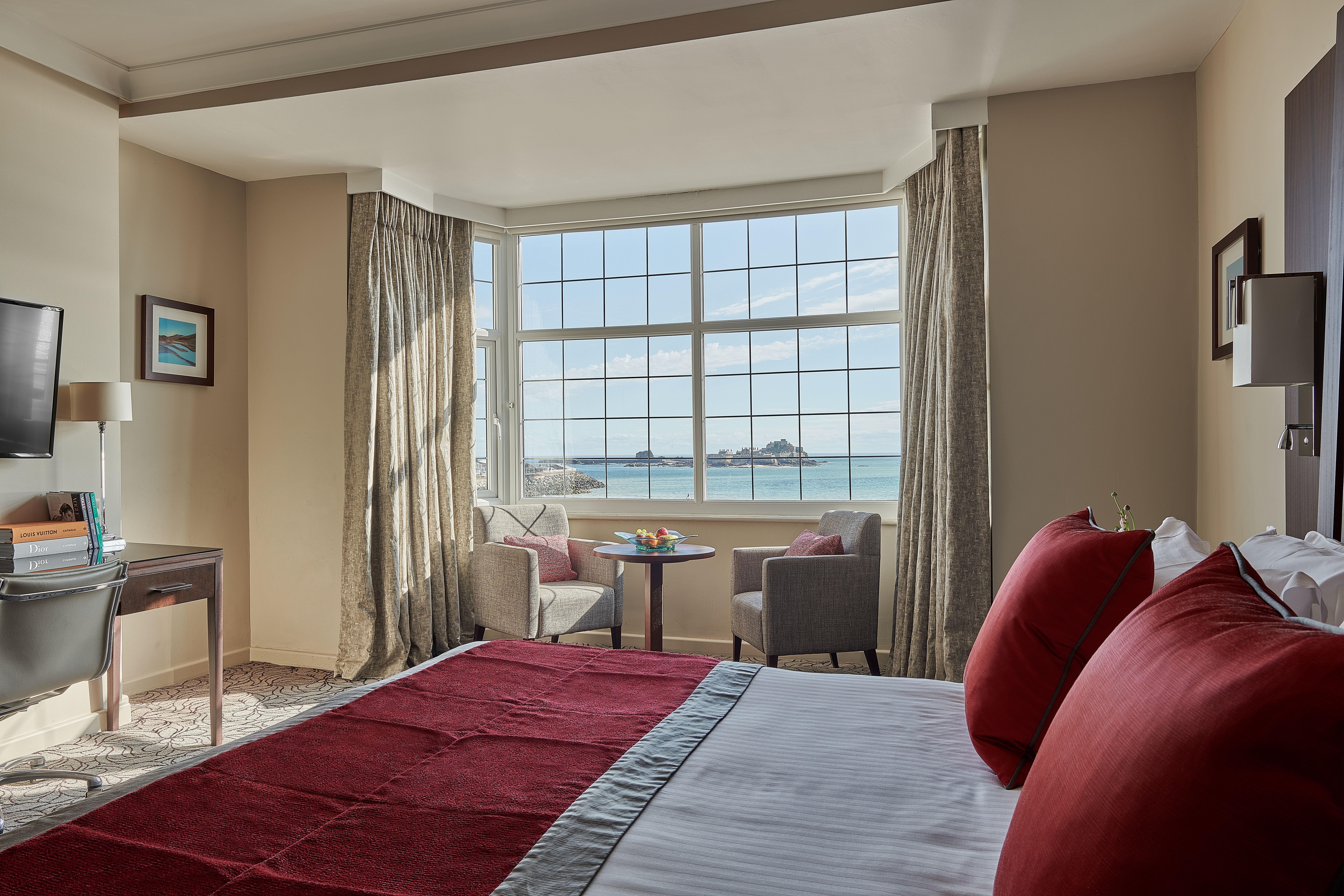 Room inside the Grand Jersey hotel. There is a bed and a chair. 